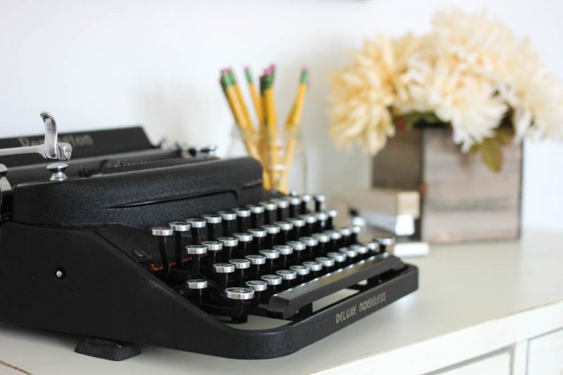 home office decor - typewriter, stapler, pencils and flowers