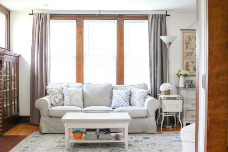 This budget-friendly IKEA slipcovered sofa and gorgeous neutral rug make perfect kid-friendly decor in a modern farmhouse living room that looks incredibly stylish and can hold up to life with kids