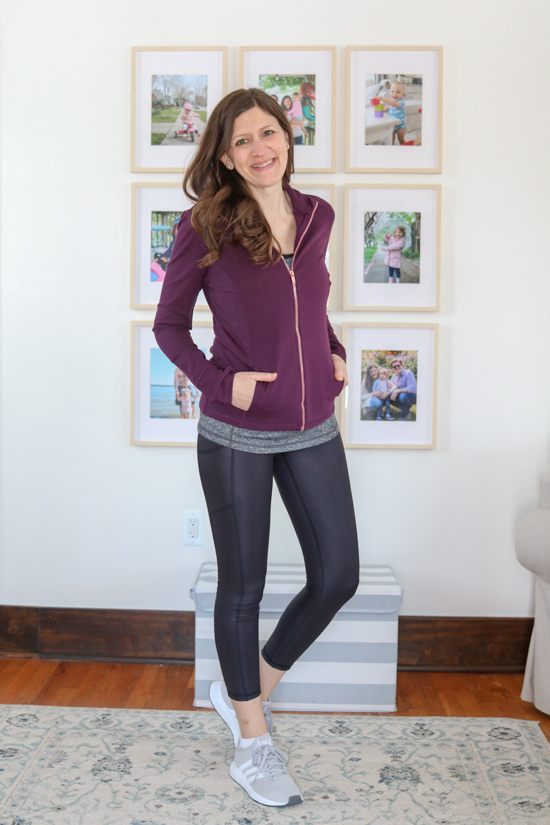 woman wearing blackberry wine colored contour zip-up jacket and shiny black leggings from Wantable Active Edit