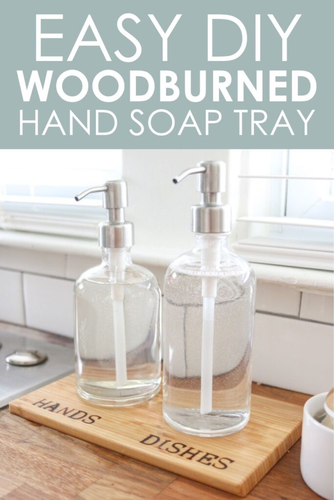 Glass kitchen soap dispensers resting on a wood tray with woodburned HANDS and DISHES labels 